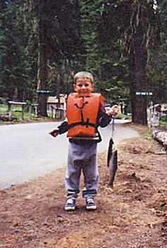 A child pulls up on a string that is holding 2 fish of total mass 5