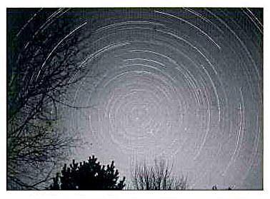 The stars appear to move across the sky and revolve around a celestial pole. This motion is caused the Earth's rotation about its own axis.