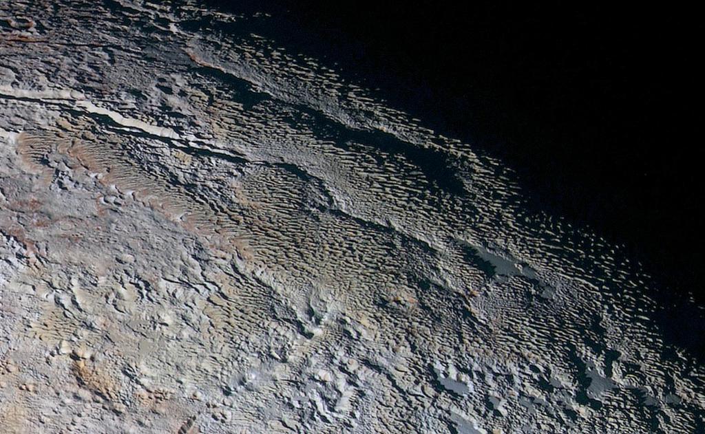 11 Pluto s surface In this extended color image of Pluto taken by NASA s New Horizons spacecraft, rounded and bizarrely textured mountains, informally named the Tartarus Dorsa, rise up along Pluto s
