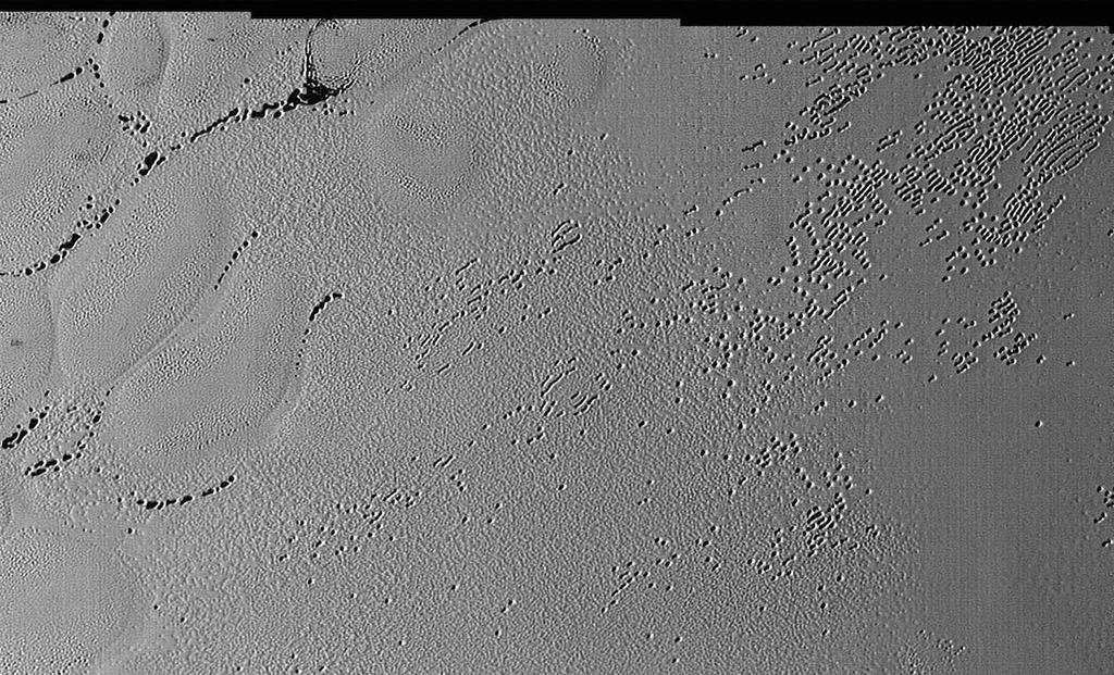 12 Pluto s surface This image from the heart of Pluto s heart feature shows the plains enigmatic cellular pattern (at left) as well as unusual clusters of small pits and troughs (from lower left to