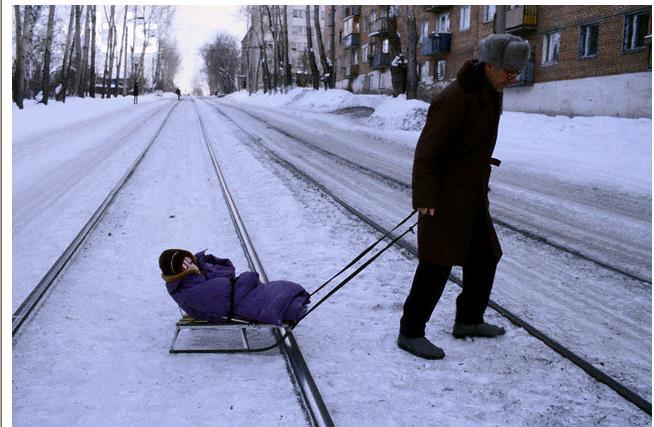 Kansas Style Sledding: While the man pulls with 30 N on the rope, the 5 kg sled with the 10 kg child moves at a