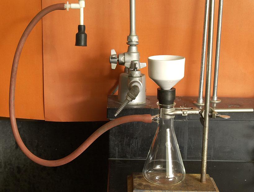 6. After the reaction has gone on for 15 minutes at 100, add 1 ml of deionized water to the flask. This water will react with any excess acetic anhydride, converting it to acetic acid.
