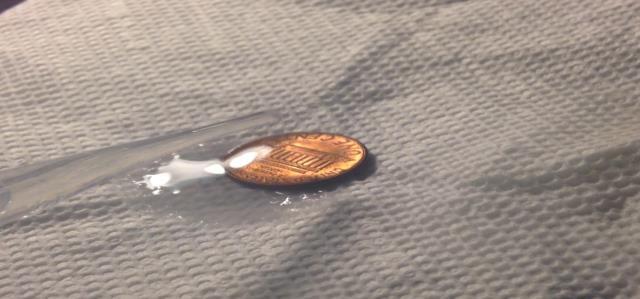Place a clean, dry penny on a paper towel on a stable surface. 2.