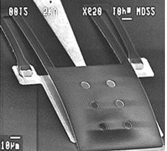 1 (right) present a scanning electron microscope image for one of our fabricated devices. The cantilever tip is in contact with a metal tip pad on the surface.