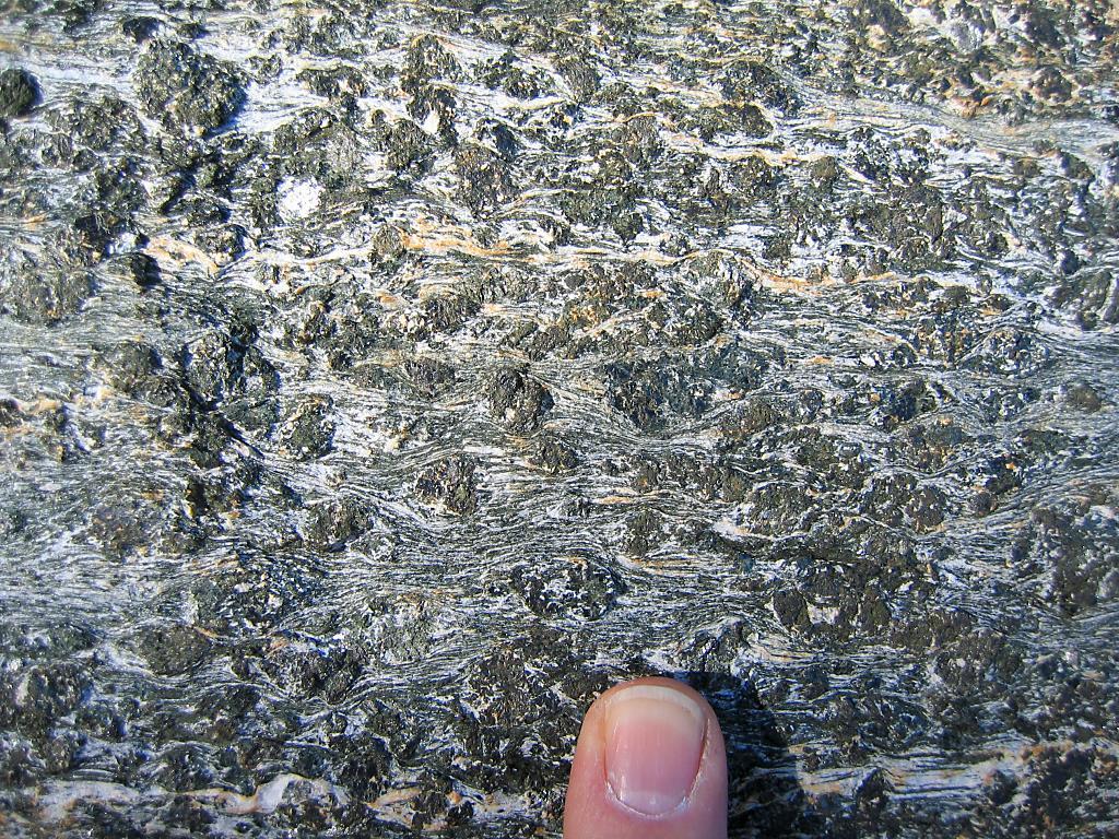 Color: Grayish-green. Texture: Dark-green, equant porphyroclasts surrounded by an irregular foliation. Grain size: Porphyroclasts are mostly 3-10 mm across, in a fine-grained matrix.