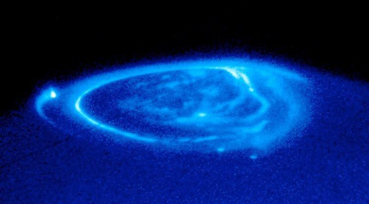magnetic field of Jupiter, and this interaction causes gases in the upper atmosphere to fluoresce near the magnetic poles The image to