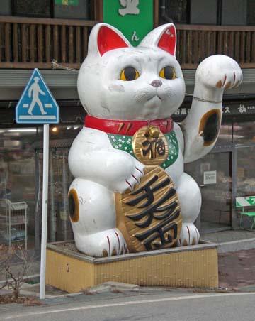 The Waving Cat The Waving Cat There is one story that illustrates how something can come to be recognized as a kami. Once an emperor was traveling in a rainstorm.