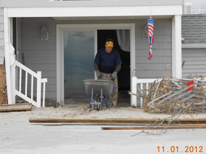 Picture 1 Picture 2 Picture 3 and Picture 4 respectively show sand deposits inside a beach front house in Ocean City and piles of sand from shoveling part of a street in Rockaway Beach.