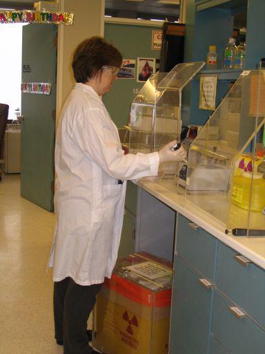 Note the lab coat, gloves, closed toes shoes and pants.
