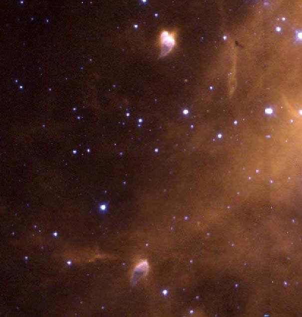 To the lower left of the starburst cluster in the full image are two compact, tadpole-shaped emission nebulae (pictured above center top and bottom).