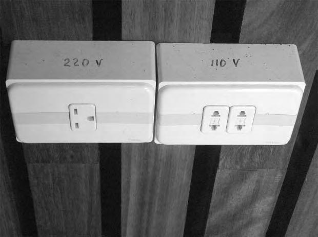 (c) Different countries supply mains electricity at different voltages. Many hotels now offer a choice of voltage supplies as shown in the photograph.