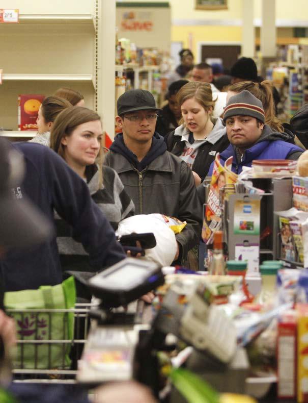 People wait in line to buy groceries before a blizzard.