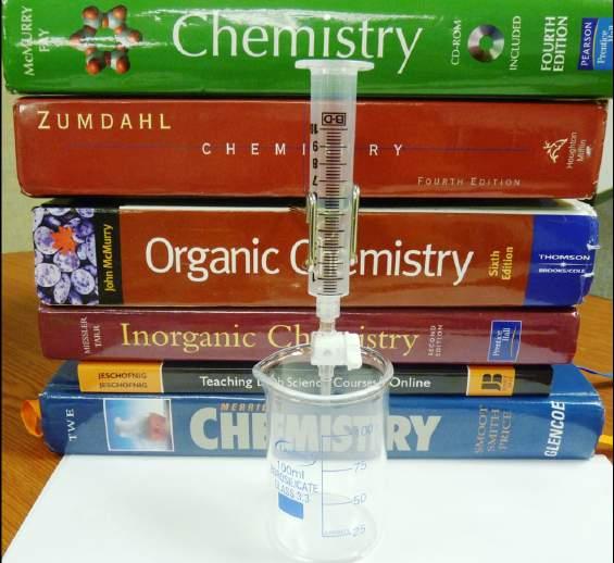 4. Stack the 5 textbooks or stack 2 textbooks on top of the lab kit box. 5. Clamp the test tube holder around the middle of the titrator and slide the long end under the top 2 books in the stack.
