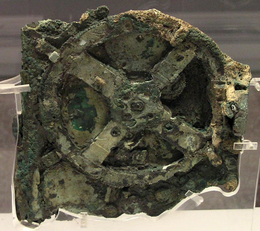 computer is the Antikythera mechanism, a geared device used by the ancient Greeks to predict astronomical events, below you can see what this device looks like now (left) and a reconstruction of what