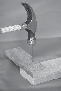 6 The photograph shows a hammer just before it hits a nail. (a) The mass of the hammer is 0.50kg. When it hits the nail, the hammer is travelling downwards with a velocity of 3.1m/s.
