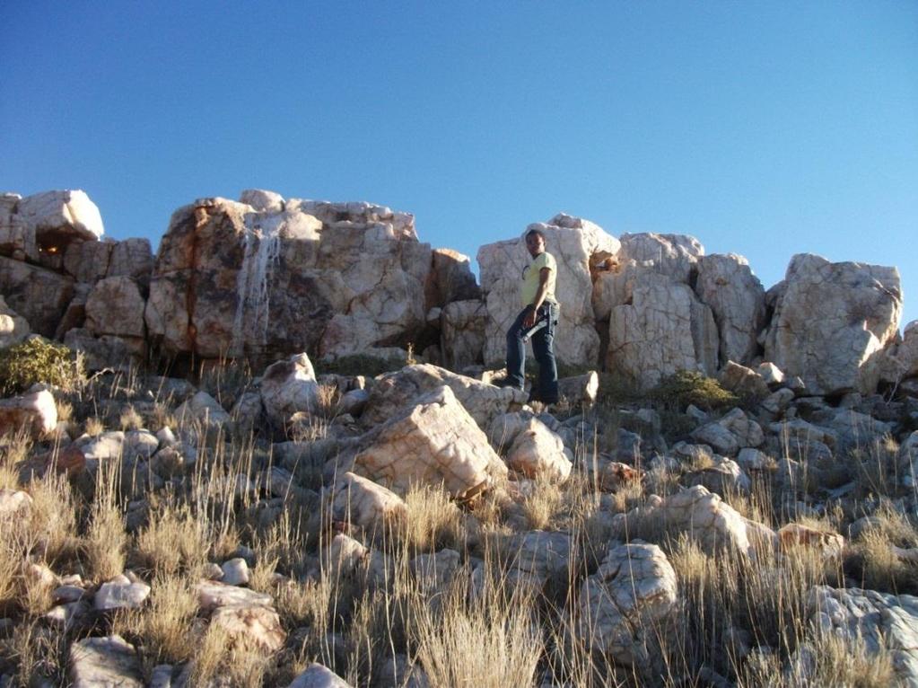 Figure 4.18 Quartz Pegmatite (height of man= 1.7m) 4.6.2 Petrography This rock consists of Quartz (40%), Black Feldspar (30%), Biotite (10%), Orthopyroxene (5%) and Plagioclase (15%) (Figure 4.19).