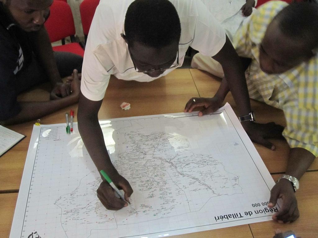 Survey technical team identifying and labelling sampling points on large scale map of Tillaberi