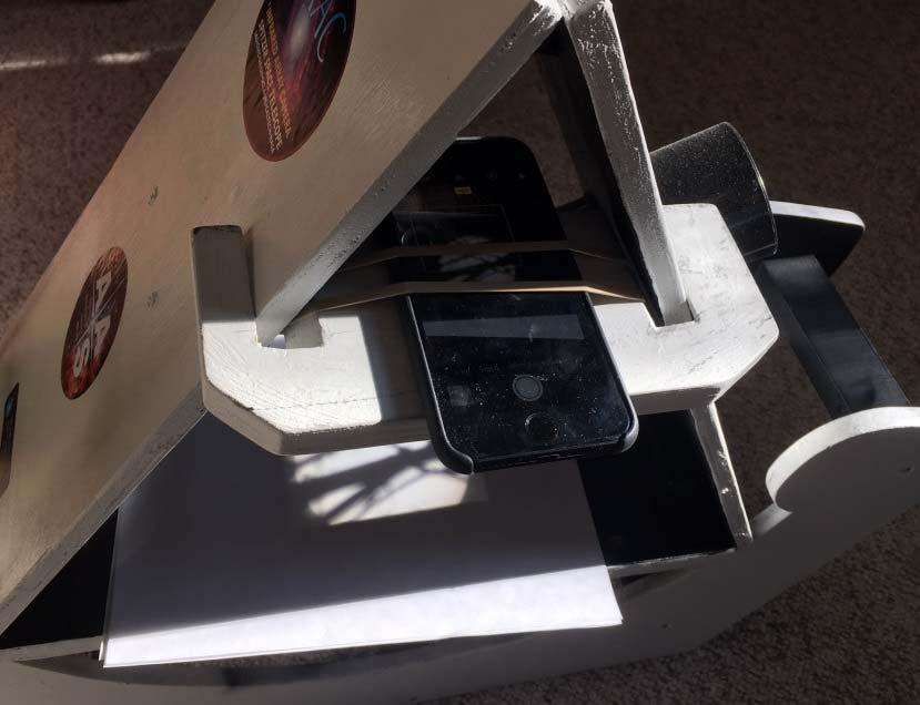 Camera phone holder In order to take images and time lapse movies of the eclipse, we built a removeable shelf that can be used to hold a camera phone on the frame that can be positioned to view the