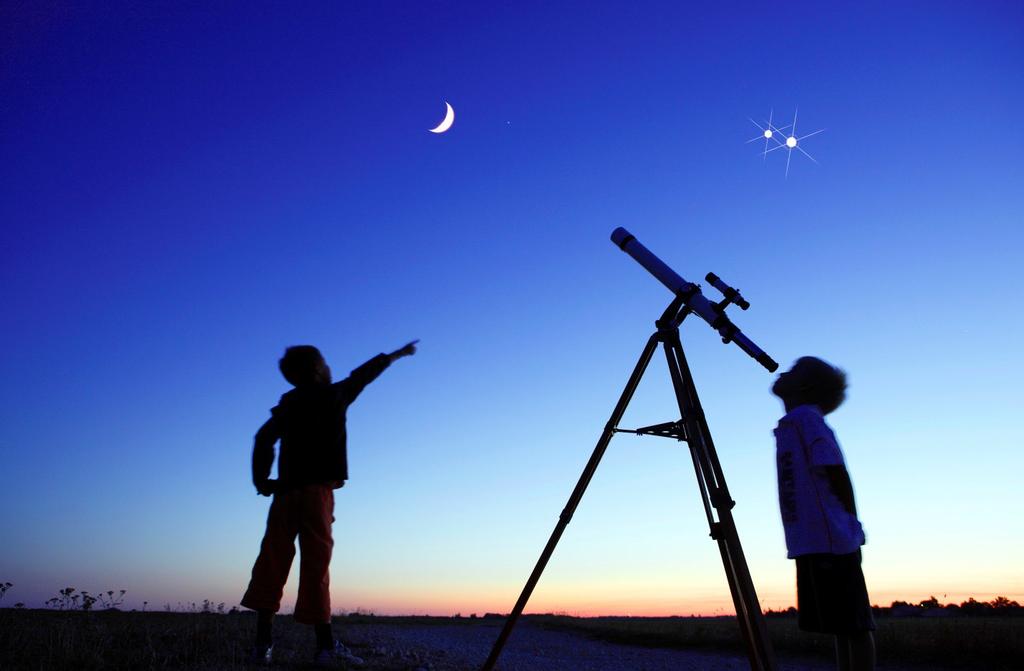Ancillary Material Image 1 Telescope Picture Description: Image 1 shows two boys standing in a field in the evening. There is a moon and two stars in the sky.