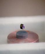 cup.) A smaller magnet levitates about a centimeter above it.