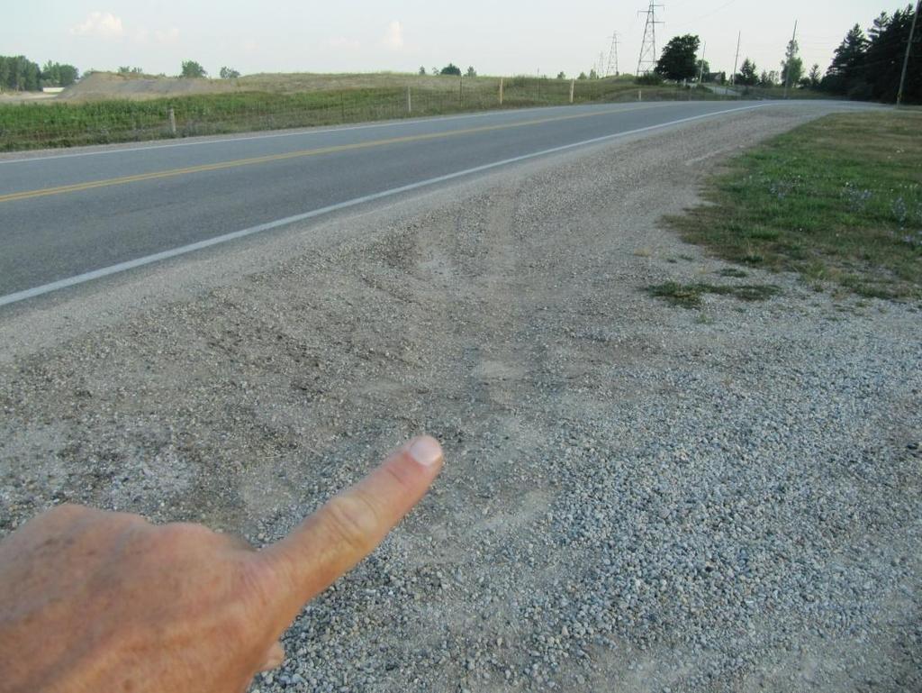 Figure 16: View, looking northward, showing the tire marks in the gravel as we look back to where the vehicle first exited the road surface. 3.