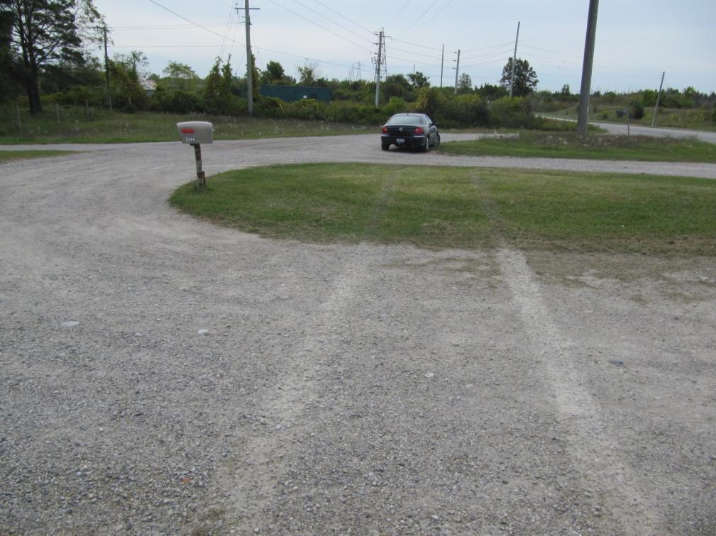Figure 28: View, looking south, at the tire marks visible on the gravel driveway.