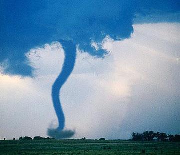 A tornado is a rapidly whirling, funnel-shaped cloud that extends down from a