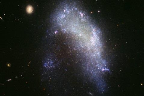 NGC-1427A: THE IMPENDING DESTRUCTION OF NGC 1427A What happens when a galaxy falls in with the wrong crowd? The irregular galaxy NGC 1427A is a spectacular example of the resulting stellar rumble.